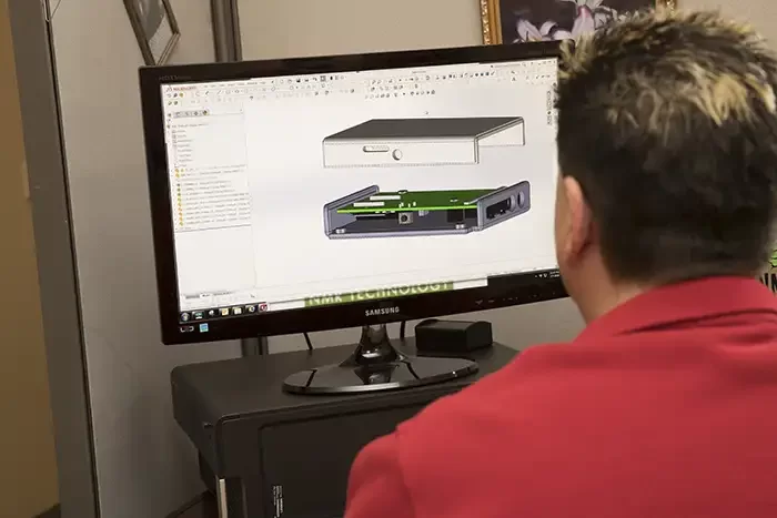 Designer reviewing a 3D CAD model of a plastic enclosure