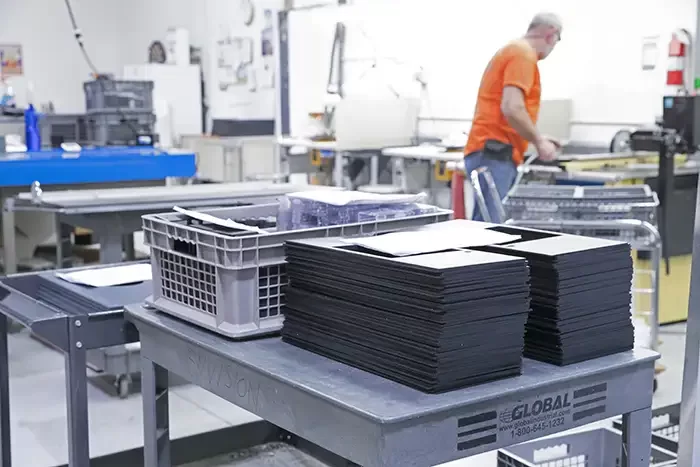 Stacks of black plastic panels on a cart on the Envision production floor